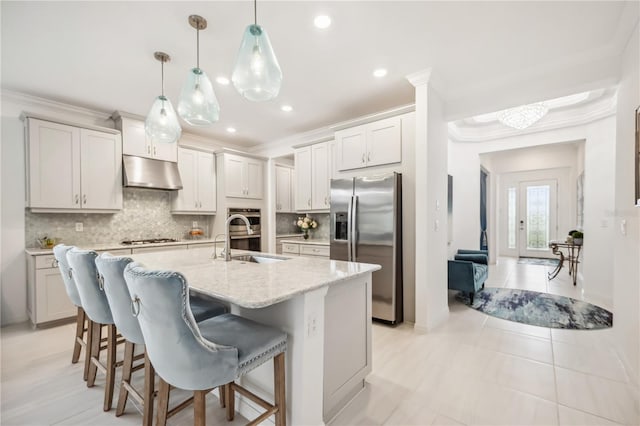 10179 Milky Way Cir, Sarasota, FL 34241 - kitchen featuring decorative backsplash, a kitchen breakfast bar, a sink, under cabinet range hood, and stainless steel appliances