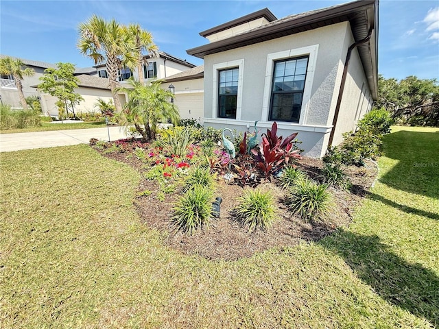 10179 Milky Way Cir, Sarasota, FL 34241 - view of property exterior featuring a garage, a yard, stucco siding, and driveway