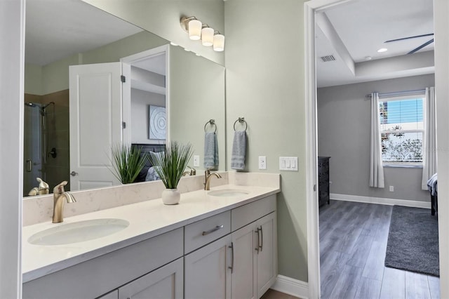 bathroom featuring double vanity, a stall shower, visible vents, and a sink