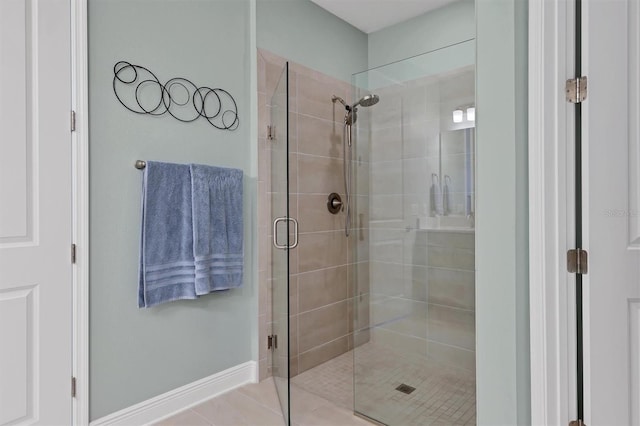 bathroom featuring baseboards, a shower stall, and tile patterned floors