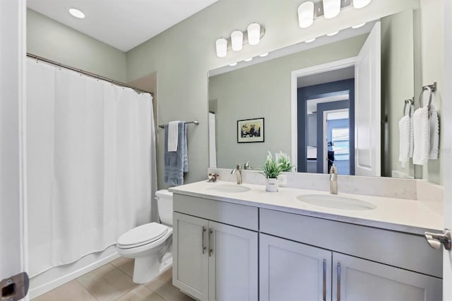 bathroom featuring tile patterned flooring, a sink, toilet, and double vanity