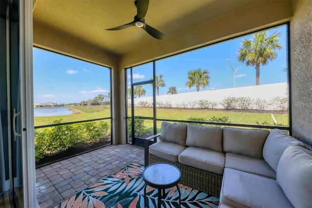 sunroom featuring a healthy amount of sunlight, a water view, and ceiling fan