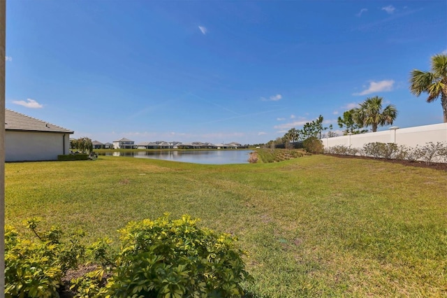 view of yard with a water view and fence