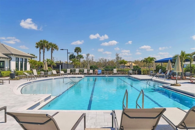 pool with a patio area and fence