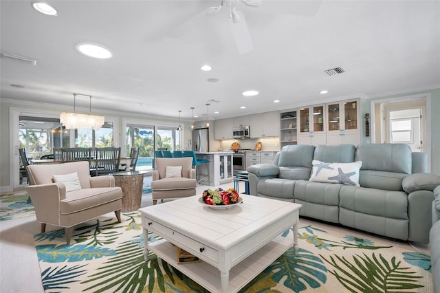 living area featuring a chandelier, visible vents, recessed lighting, and ornamental molding