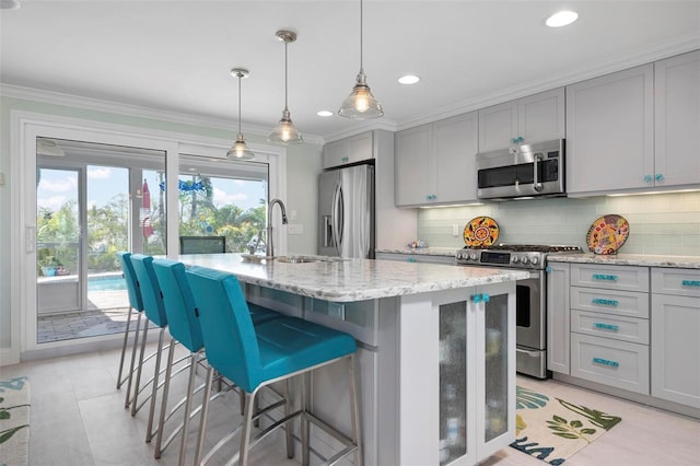 kitchen featuring a sink, stainless steel appliances, ornamental molding, and decorative backsplash