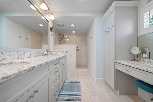 bathroom with double vanity, visible vents, a sink, and a walk in shower