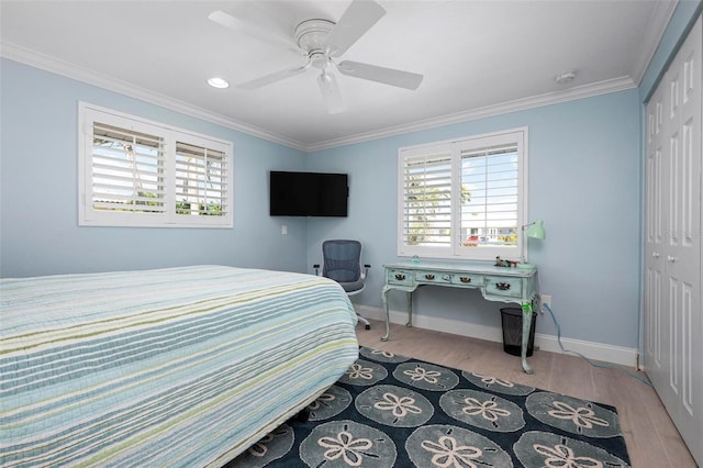 bedroom featuring light wood-type flooring, a closet, baseboards, and ornamental molding