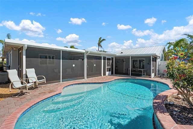 view of pool with a patio, fence, a fenced in pool, and a sunroom