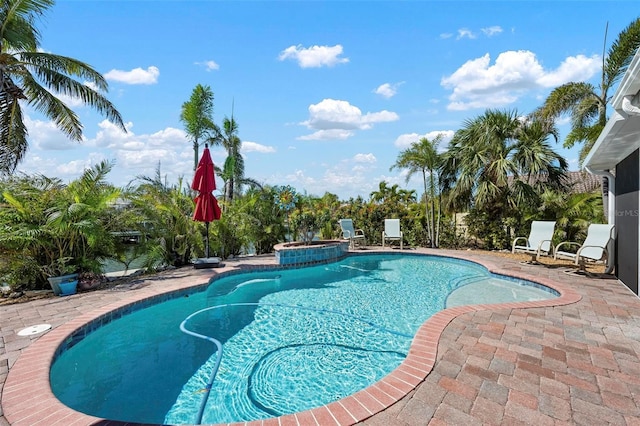 pool with a patio and an in ground hot tub