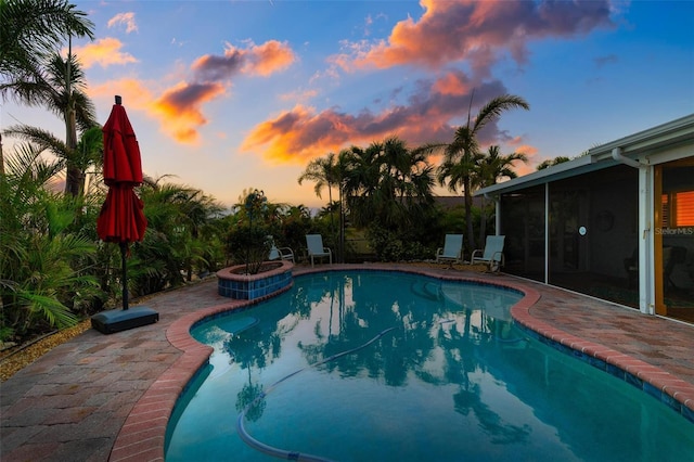 view of pool with a patio area, a pool with connected hot tub, and a sunroom