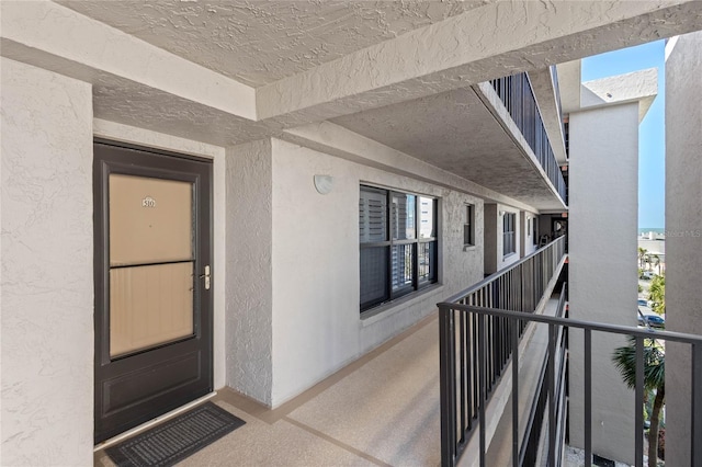 view of exterior entry featuring stucco siding and a balcony