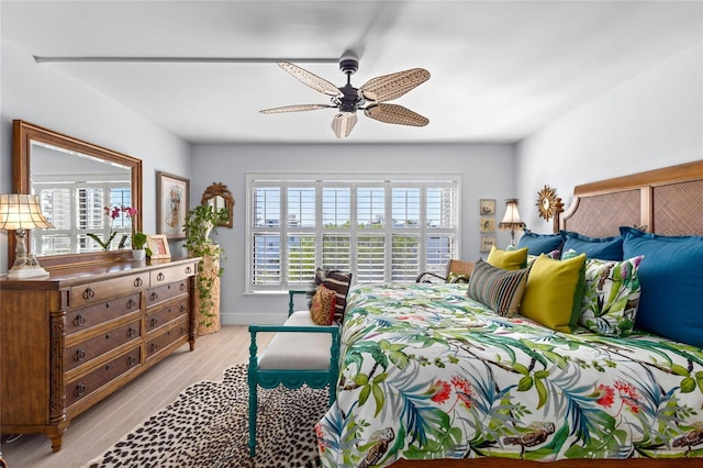 bedroom featuring light wood-style flooring, baseboards, and ceiling fan