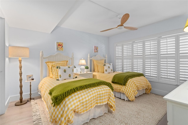 bedroom with light wood-type flooring, baseboards, and ceiling fan