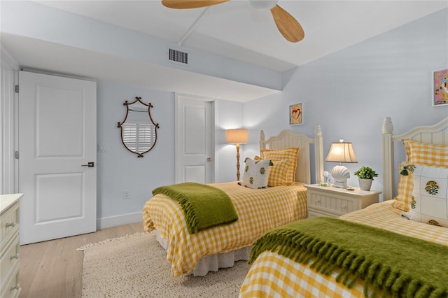 bedroom featuring light wood finished floors, visible vents, ceiling fan, and baseboards