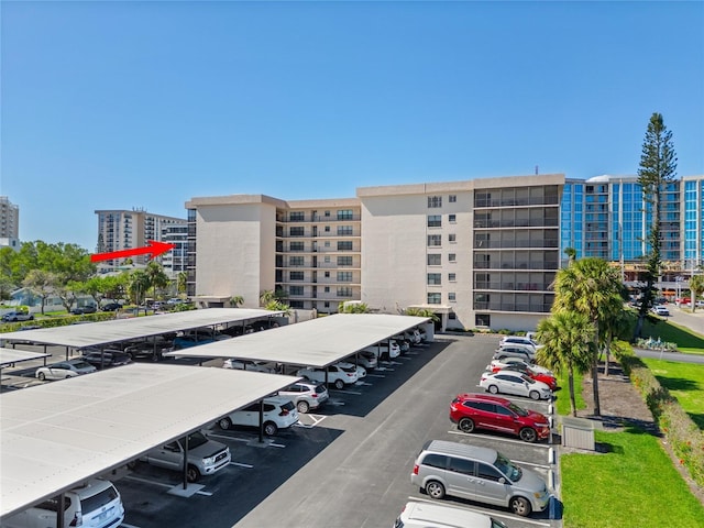 view of property featuring covered and uncovered parking