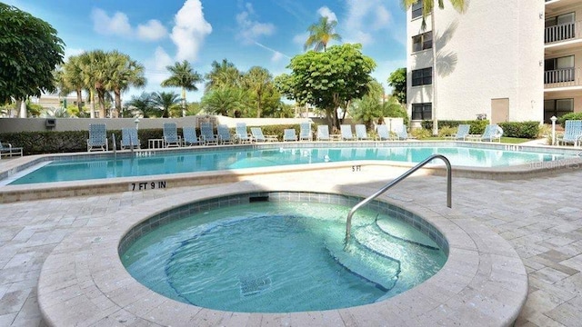 community pool with a patio and a community hot tub