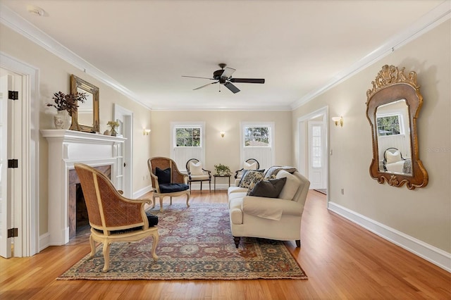 sitting room featuring baseboards, ornamental molding, wood finished floors, and a fireplace with flush hearth