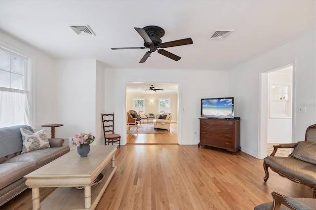 living area with light wood-style floors and visible vents