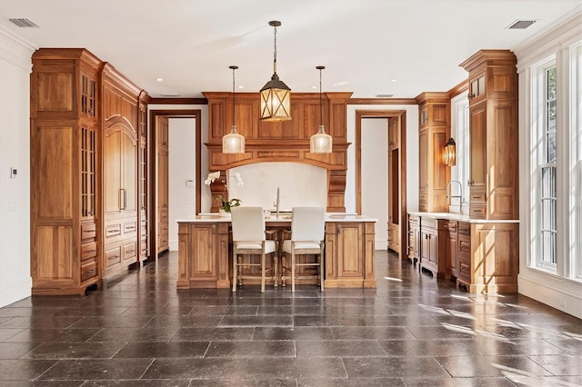 kitchen featuring visible vents, light countertops, and ornamental molding