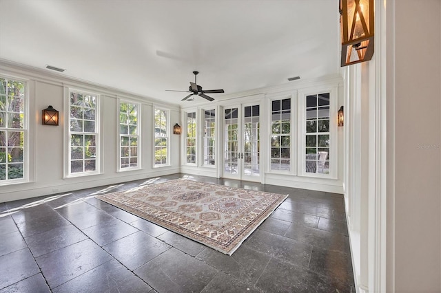 unfurnished sunroom featuring visible vents and a ceiling fan