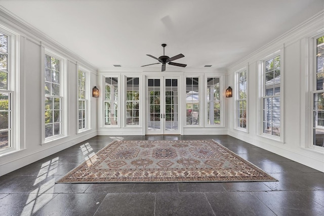 unfurnished sunroom featuring ceiling fan, visible vents, and a wealth of natural light