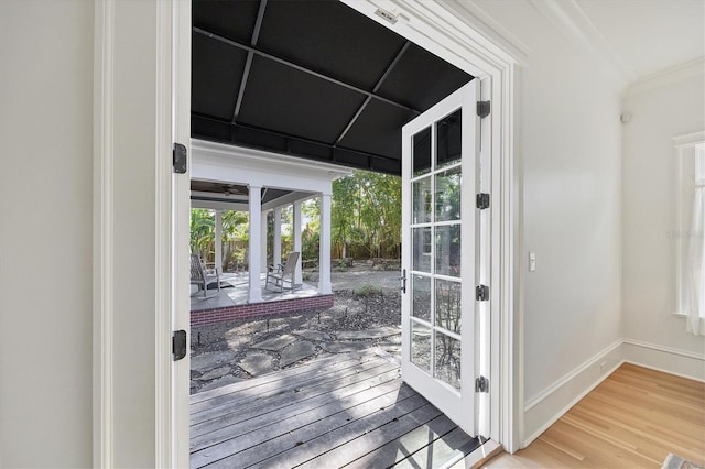 doorway to outside featuring ornamental molding, french doors, wood finished floors, and baseboards