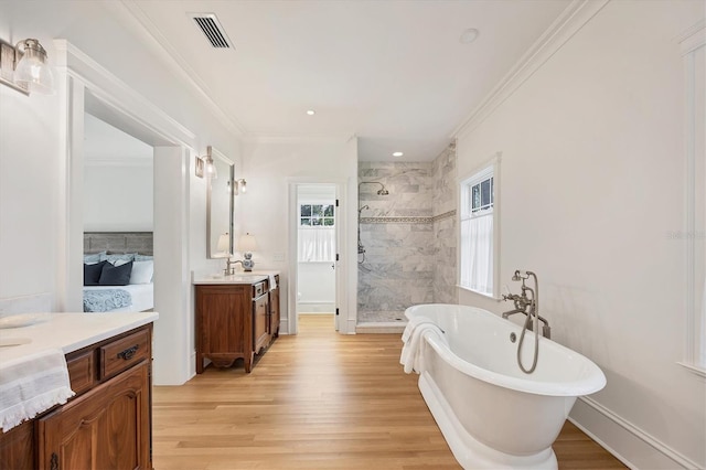 full bathroom with ornamental molding, wood finished floors, a shower stall, and visible vents