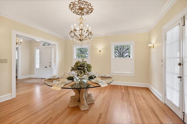 unfurnished dining area with baseboards, ornamental molding, a notable chandelier, and wood finished floors