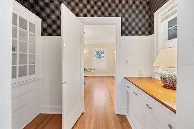 hall featuring light wood-style flooring and baseboards