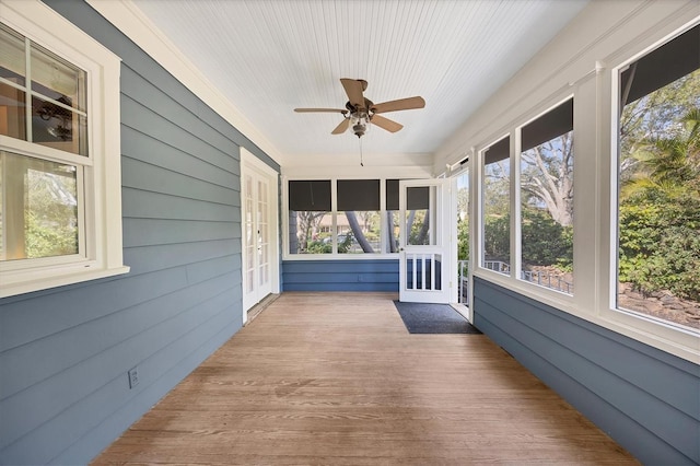 unfurnished sunroom featuring a ceiling fan