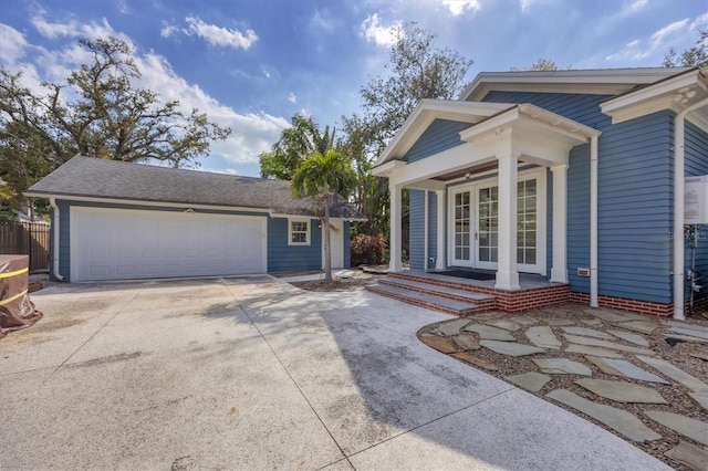 view of front of home featuring covered porch, an outdoor structure, and french doors