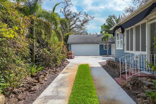 view of yard with a garage and driveway