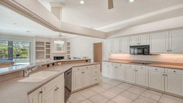 kitchen with crown molding, a fireplace, black appliances, a ceiling fan, and a sink