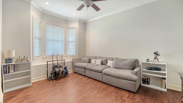 living area with ornamental molding, a ceiling fan, a textured wall, and wood finished floors