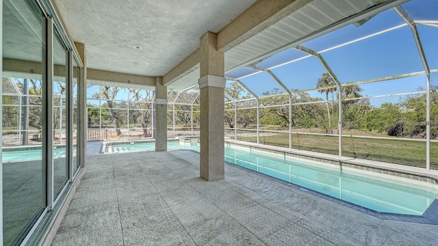 outdoor pool with glass enclosure and a patio area