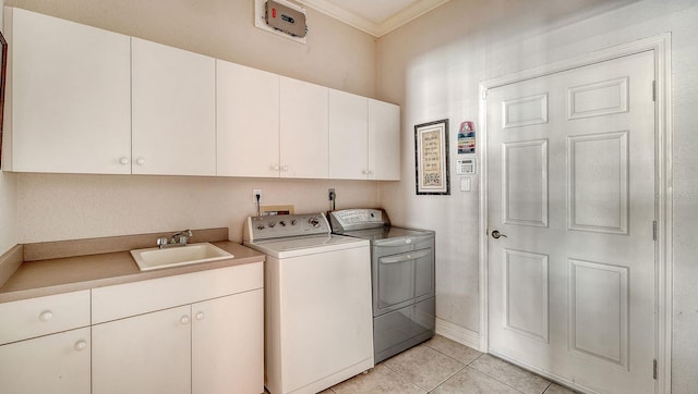 laundry area with washing machine and dryer, ornamental molding, light tile patterned flooring, cabinet space, and a sink