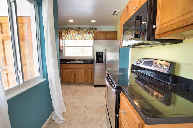 kitchen with appliances with stainless steel finishes, dark countertops, visible vents, and a sink