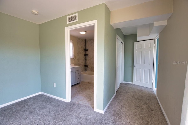 corridor with baseboards, visible vents, and carpet flooring