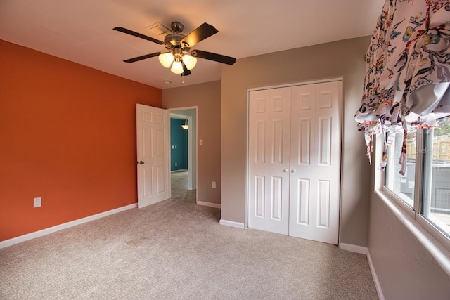 unfurnished bedroom featuring ceiling fan, baseboards, a closet, and carpet flooring