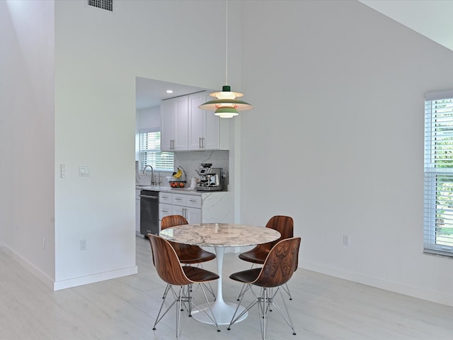 dining space featuring visible vents, light wood finished floors, and baseboards