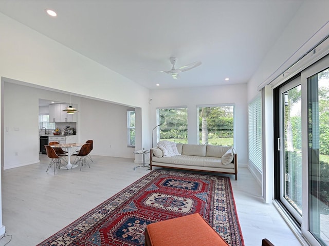 living area with light wood-type flooring, ceiling fan, baseboards, and recessed lighting