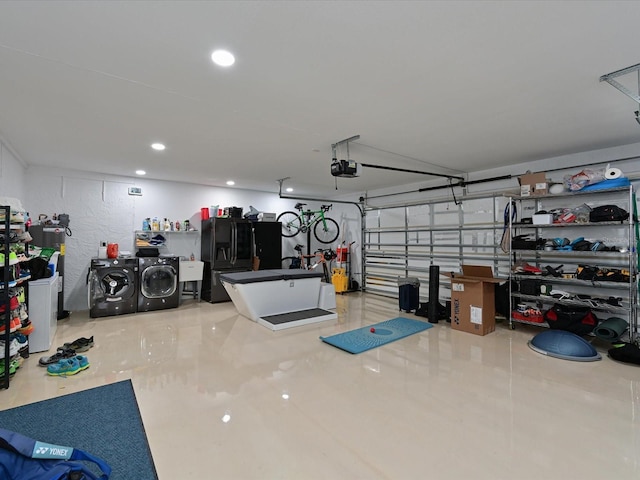 garage featuring washer and clothes dryer, a garage door opener, black refrigerator with ice dispenser, a sink, and recessed lighting