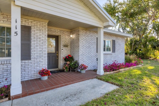 view of exterior entry featuring brick siding