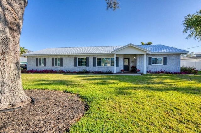 ranch-style house with a front lawn, brick siding, and metal roof