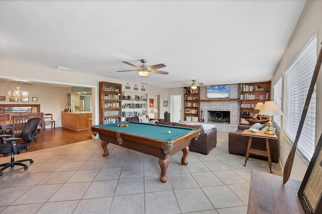 playroom featuring light tile patterned floors, built in shelves, a ceiling fan, a fireplace, and pool table