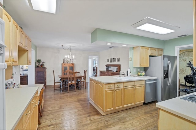 kitchen with stainless steel appliances, visible vents, light brown cabinetry, and light countertops