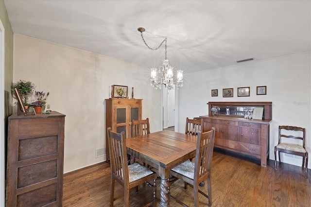 dining room featuring visible vents, a notable chandelier, and dark wood finished floors