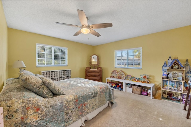 carpeted bedroom featuring ceiling fan and a textured ceiling