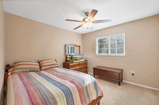 carpeted bedroom featuring ceiling fan, a textured ceiling, and baseboards